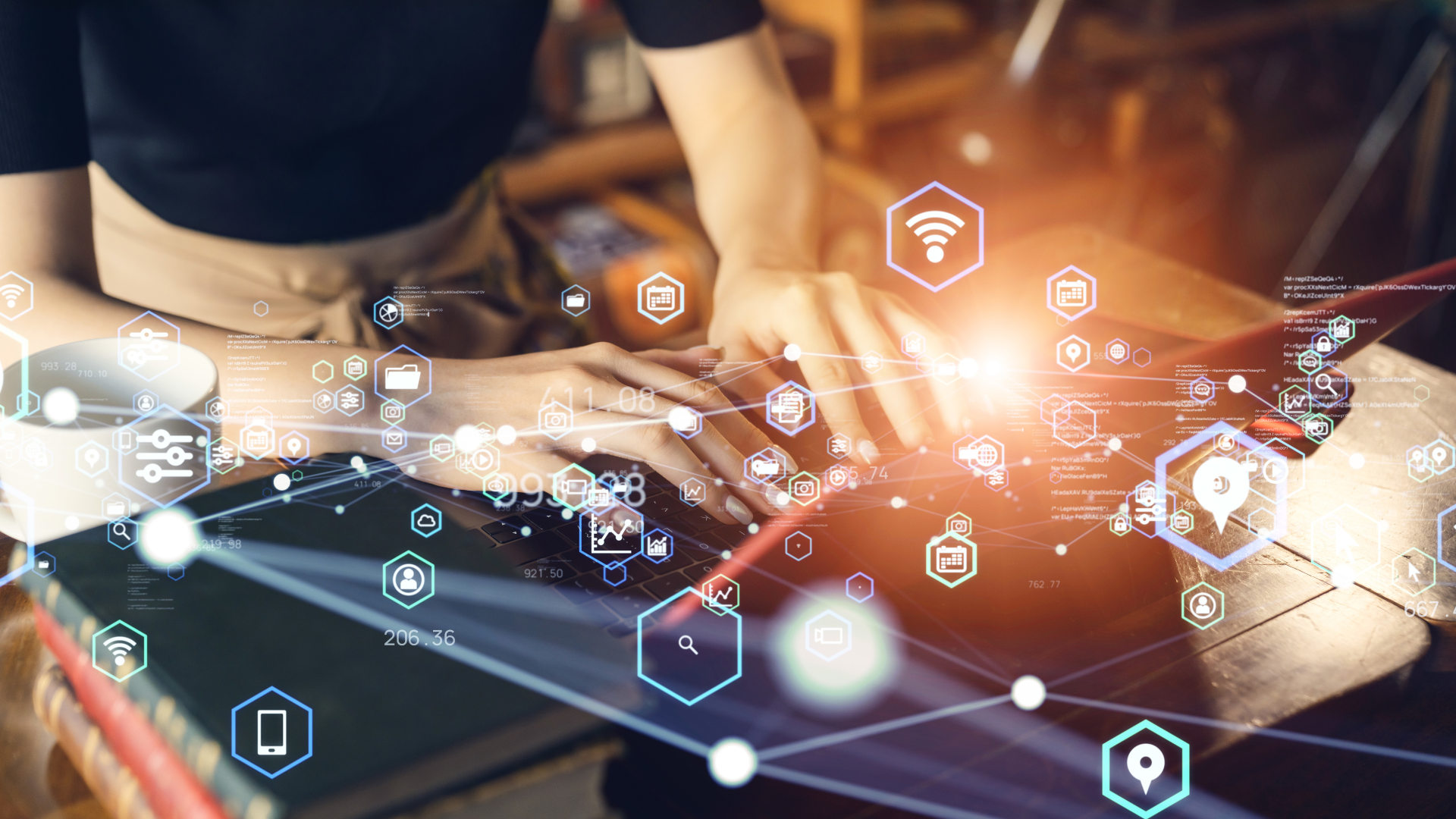 Manos escribiendo en un computador con íconos digitales flotantes, representando transformación digital y análisis de datos