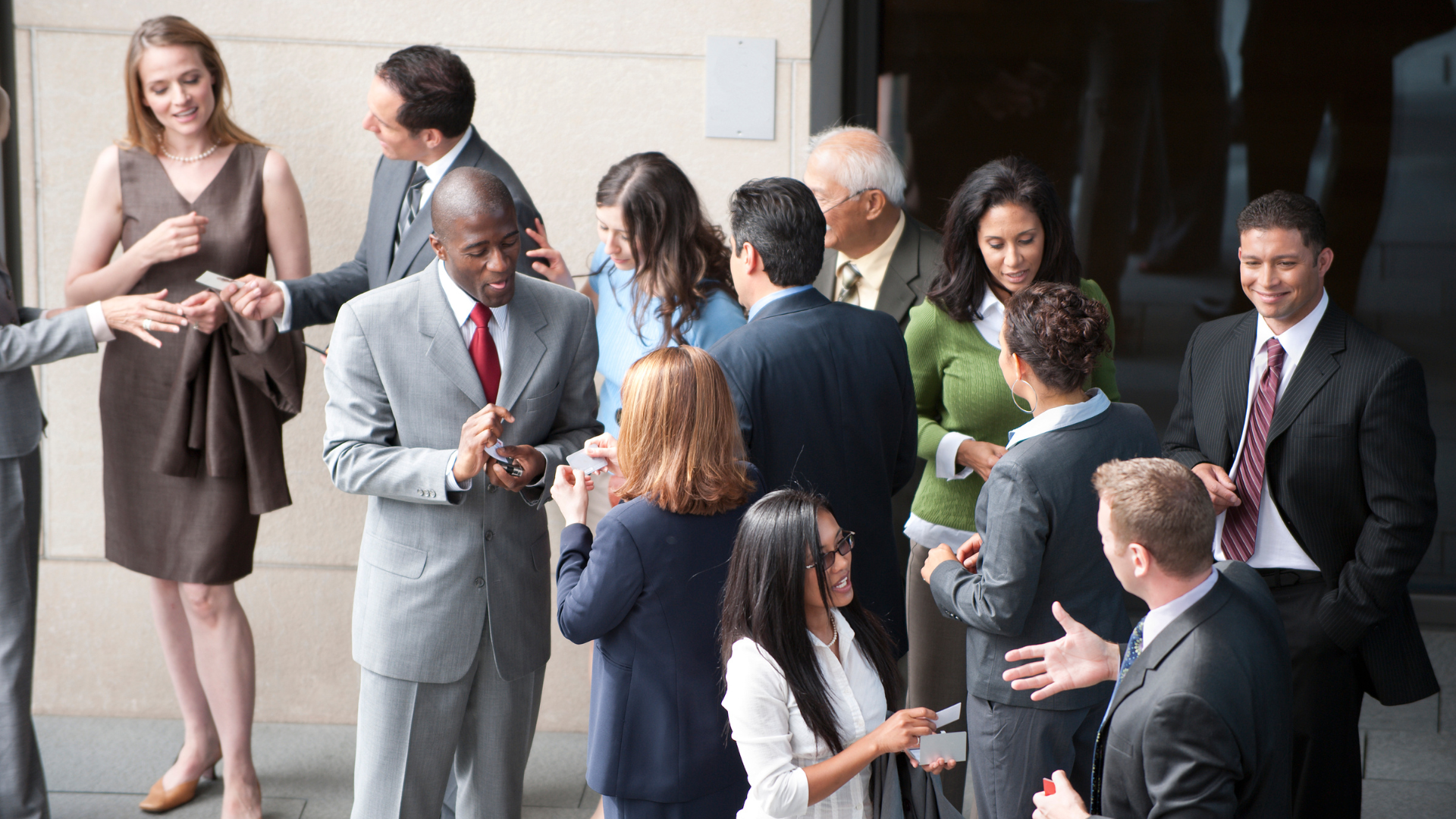 Grupo de profesionales conversando y haciendo networking en un evento corporativo al aire libre